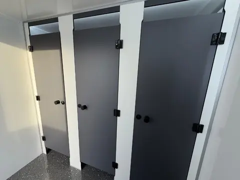 Interieur met drie witte wc’s naast elkaar behorend bij de vacuum toiletwagen GL A van Europe Wagon gefotografeerd in een nette sanitaire unit