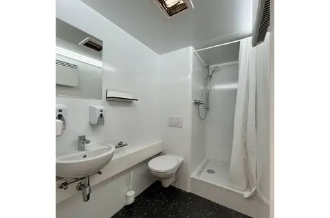 GL x BAD Een eenvoudige witte badkamer met douche wastafel en toilet
