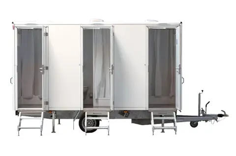 GL x BAD Een mobiele toiletcabine op een aanhanger met drie openstaande deuren