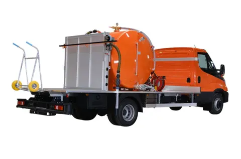 Global FXDEen grote oranje vrachtwagen met een ronde tank op de achterkant op een donkere achtergrond
