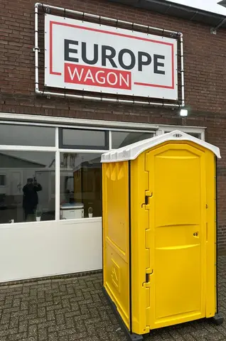 MTM Geel draagbaar toilet naast een gebouw en van binnen weergegeven