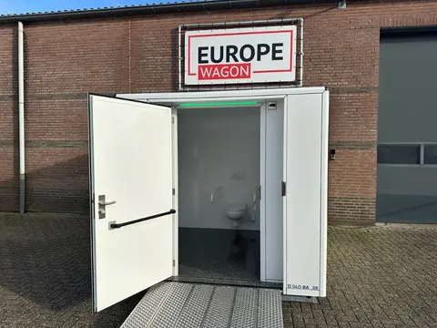 Miva container bij een bedrijfsgebouw met geopende deur
