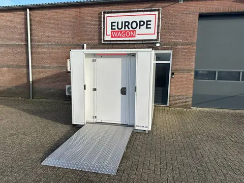 Miva container met open deur en uitgeklapte oprijplaat op een plein
