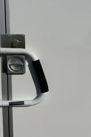 Witte deur met metalen hendel en zwart handvat
