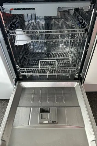 Een open vaatwasser met lege rekken klaar om in te ruimen